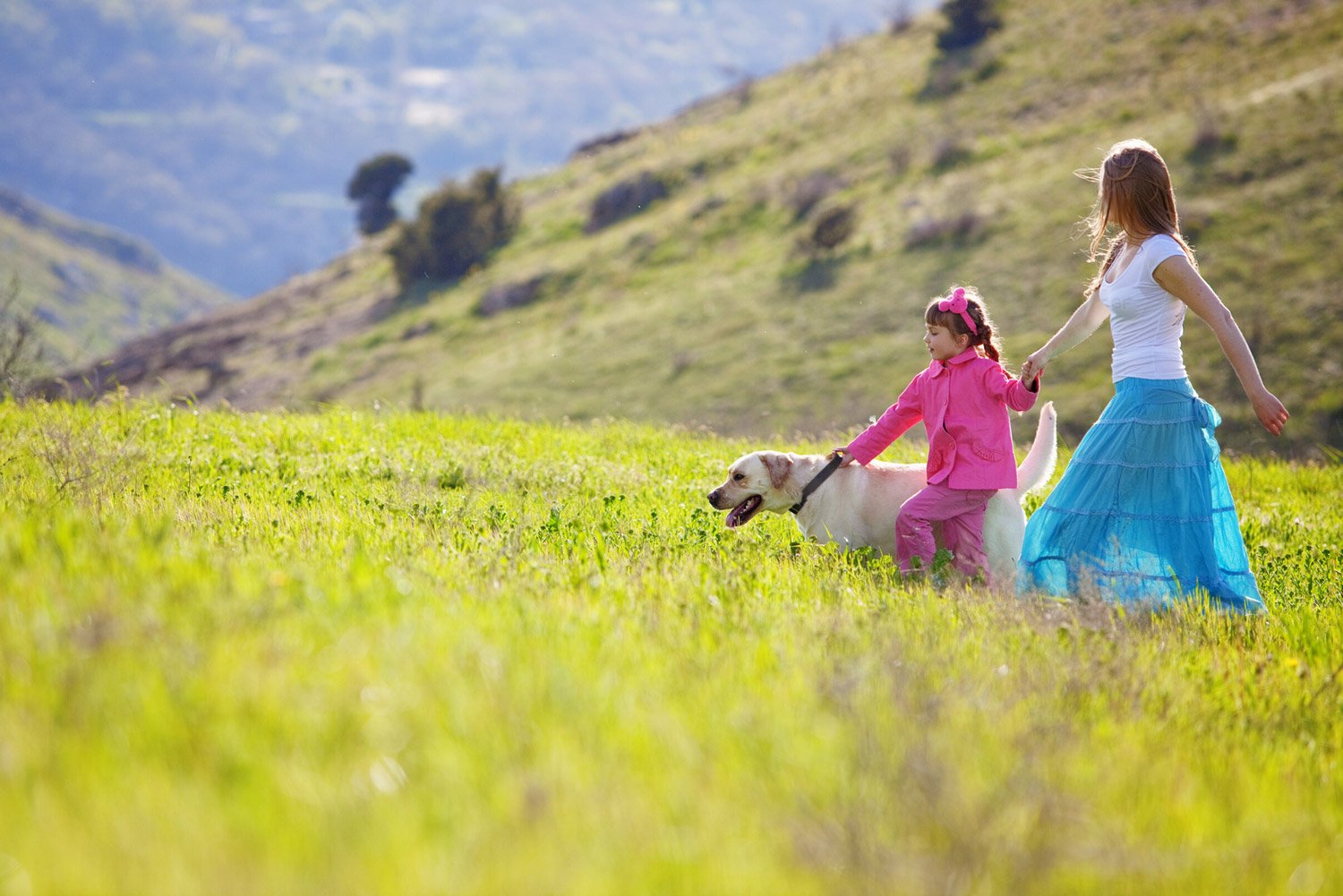 woman-and-child-in-field-with-dog